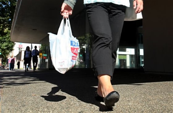 A shopper in California totes goods in a single-use plastic carryout bag.